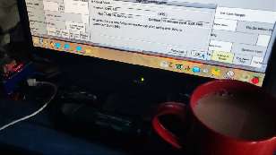 A mug of tea in front of a computer monitor