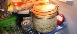 A jar of grated cheddar in the fridge.