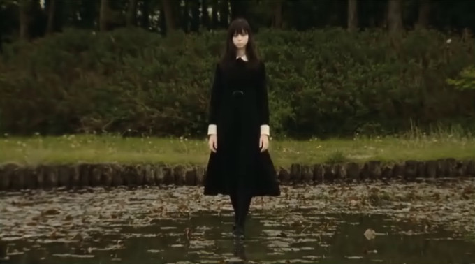 Screen capture from Fatal Frame showing a girl in school uniform walking on a pond. And I mean 'on'.