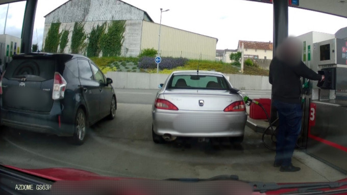A dashcam shot of some bloke really failing at filling his car