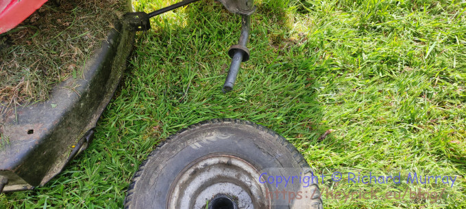 A mower missing a wheel