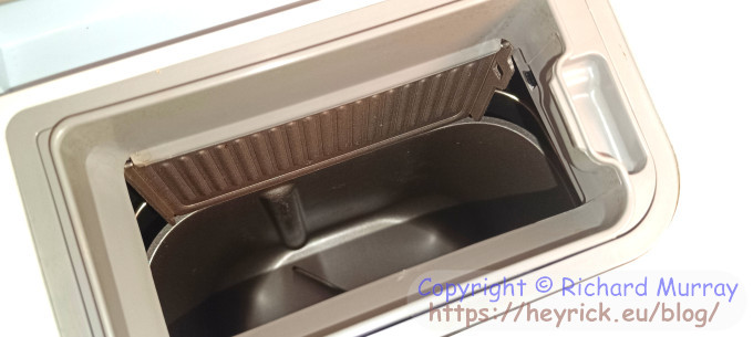 Showing the grain dispenser with the flap open.
