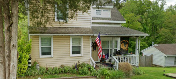 A picture from Streetview of a home proudly displaying the US flag.