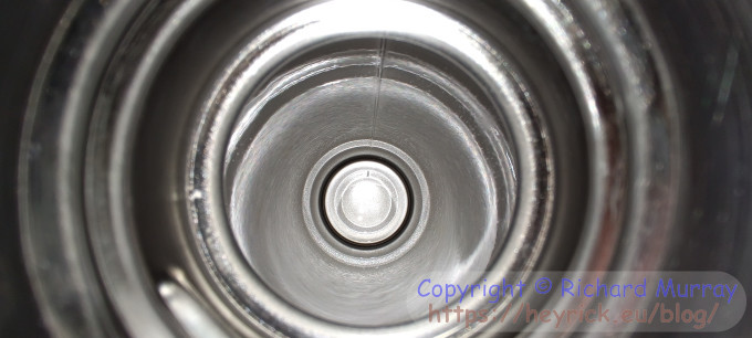 A photo loing down into a metal thermos flask.