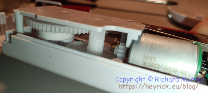 The solid plastic piece off-centre on the big gear is the key to how the machine moves.